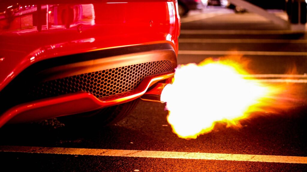 A red car with automobile exhaust system showcasing high car performance