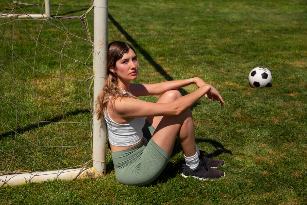 A young girl sitting in a Football Courts