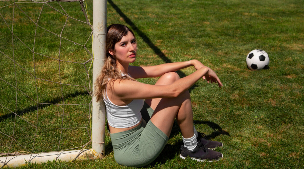 A young girl sitting in a Football Courts