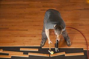 Professional installing engineered hardwood flooring in a modern home