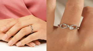 Close-up of two silver infinity rings worn on fingers, featuring delicate diamond accents and a modern infinity symbol design.