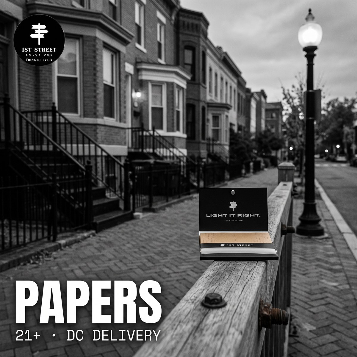 1st Street rolling papers booklet on a weathered wooden rail on a black-and-white DC rowhouse street